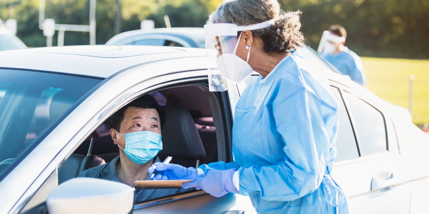 A man waits in his car at a drive-thru COVID-19 testing site.