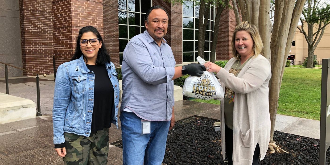 True Flavors owners Mark and Denise Hernandez delivering a meal curbside.