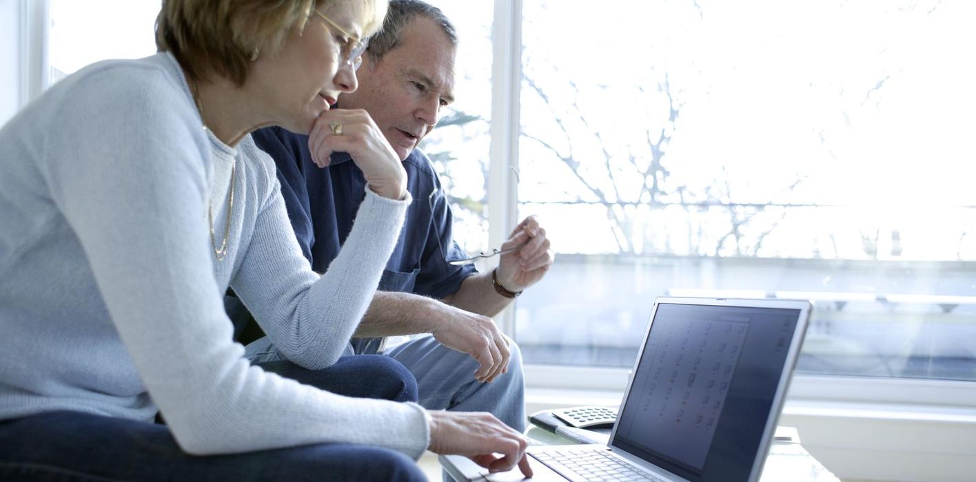 Couple looking at laptop researching can I avoid paying taxes on my 401(k) withdrawal.