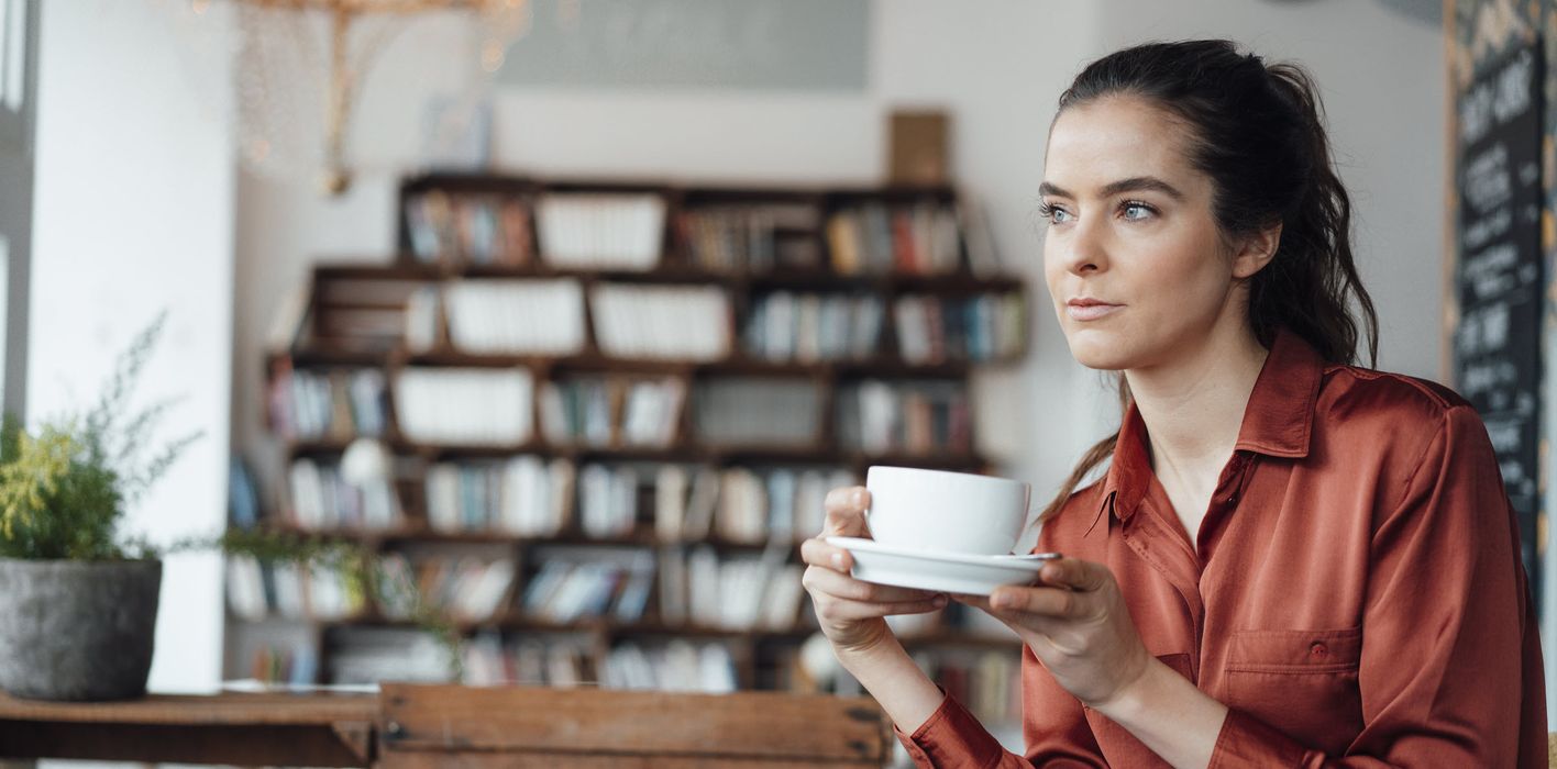 Woman drinking coffee thinking about how to prepare for a recession