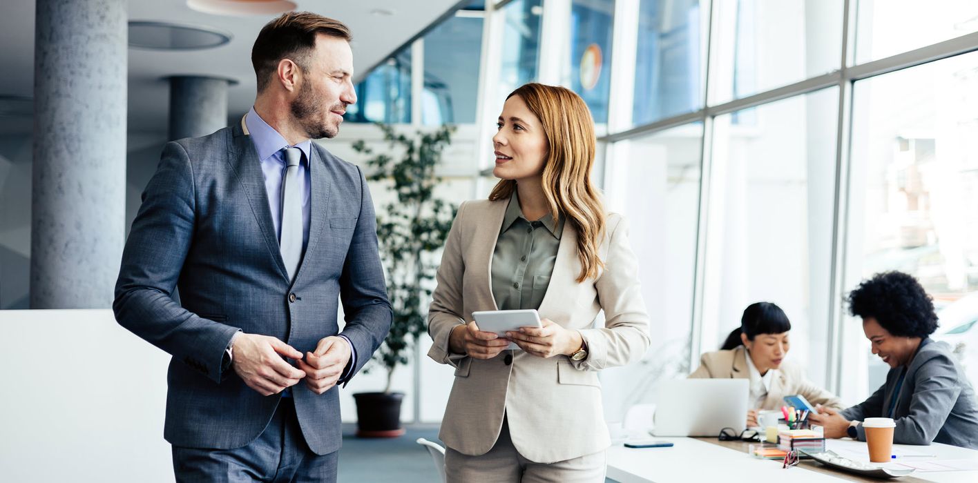 Coworkers discuss investment strategy in modern office   