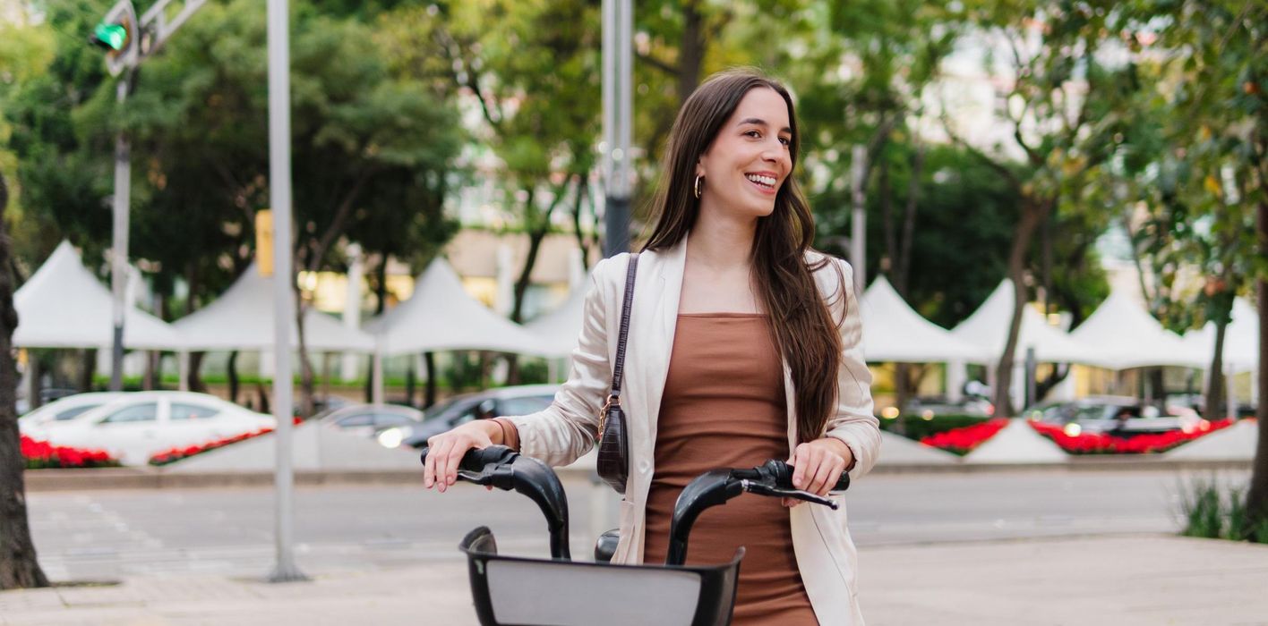 A young woman with straight hair on the street using a bicycle