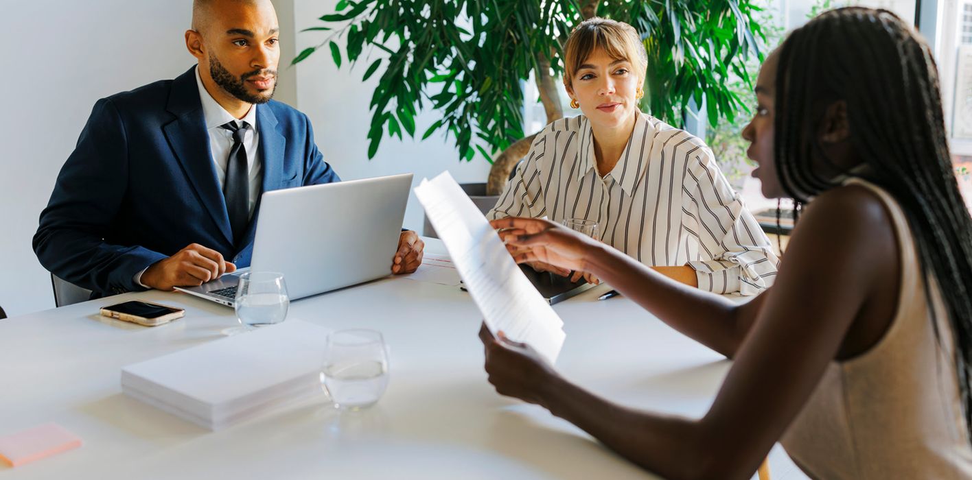 Formal business team having a meeting, discussing documents, and reviewing wealth management tools and investment strategies