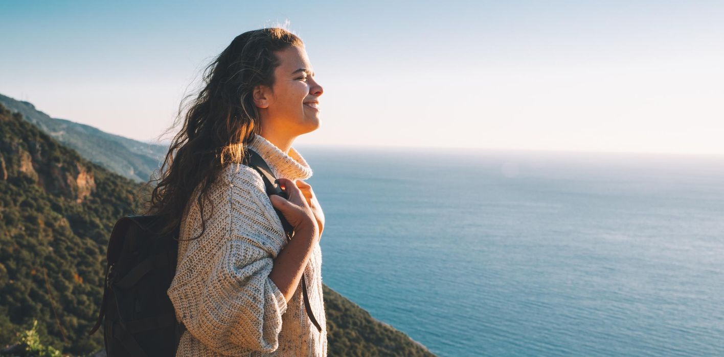 Seascape pursuit and mountain climbing for female tourist