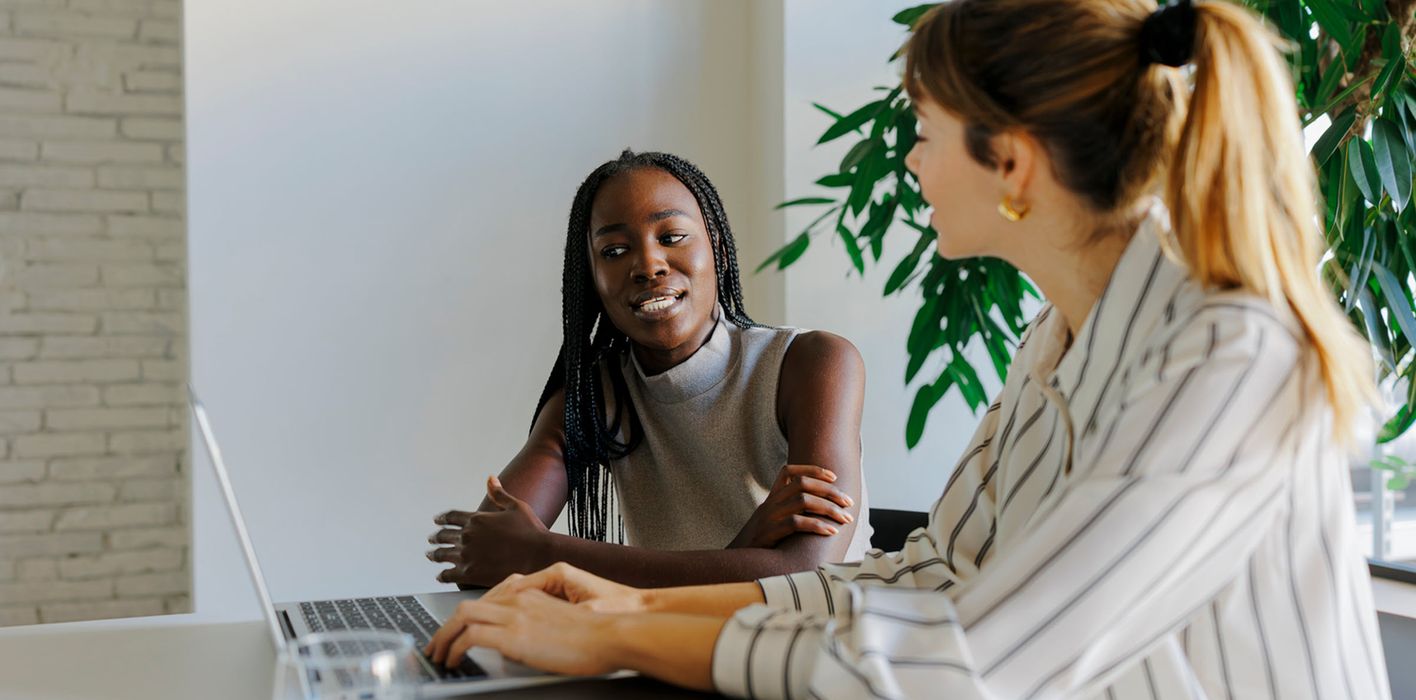 Two formal businesswomen collaborate during office meeting, discussing finance and the importance of a long-term financial plan with Northwestern Mutual