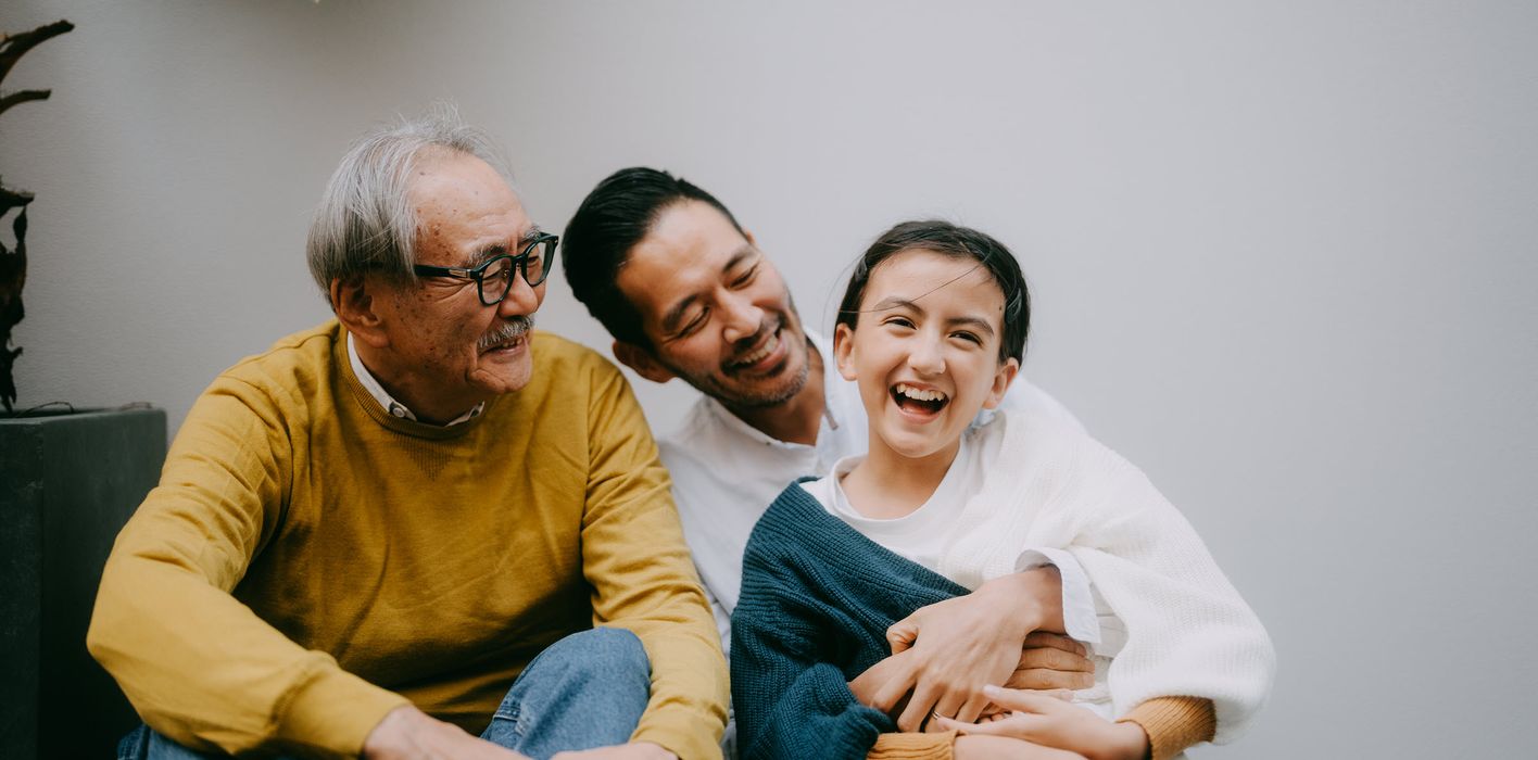 Cheerful young girl having fun with her grandfather and father