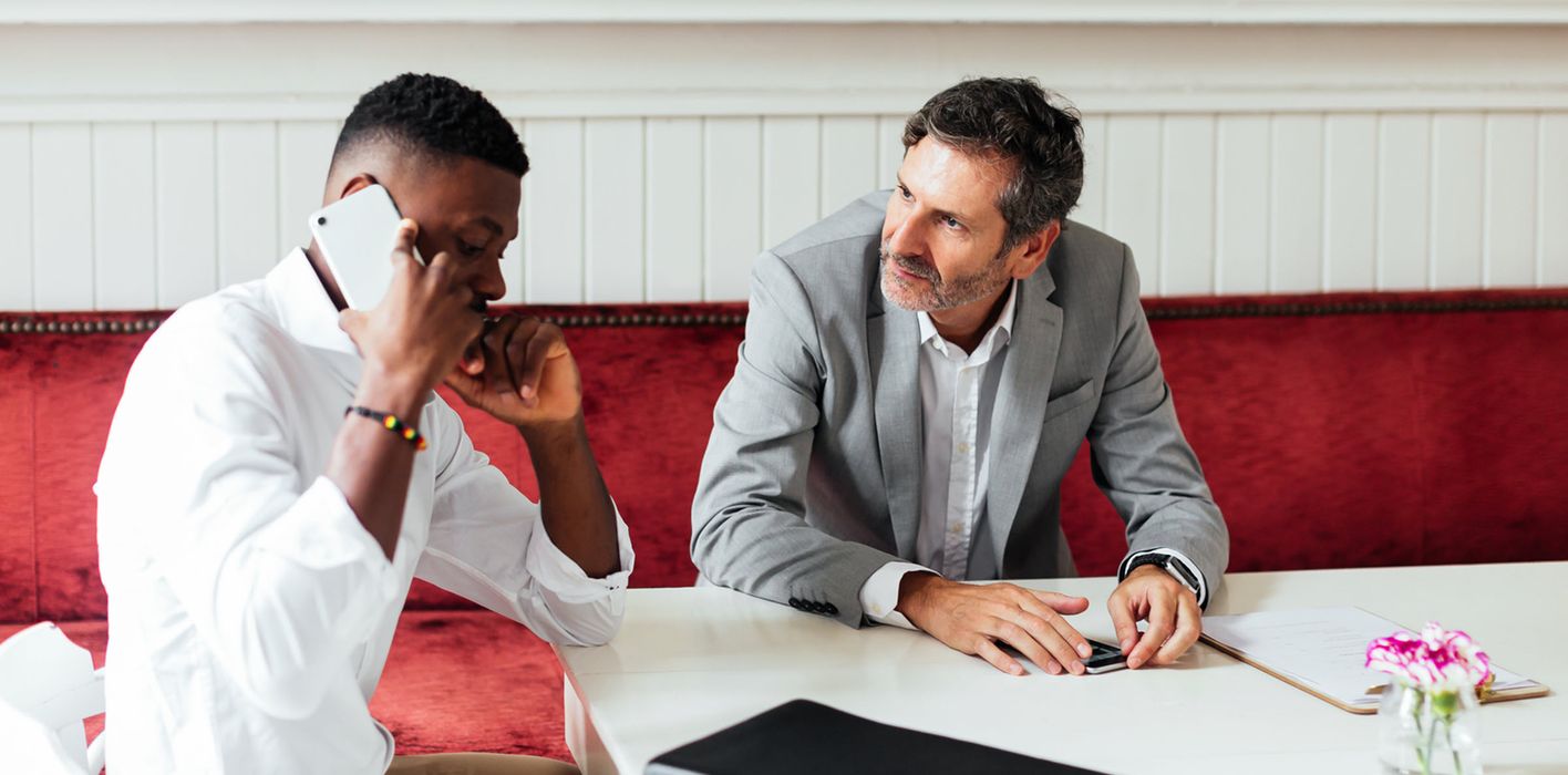 Businessmen discuss markets and economy between meetings in a modern coffee shop 