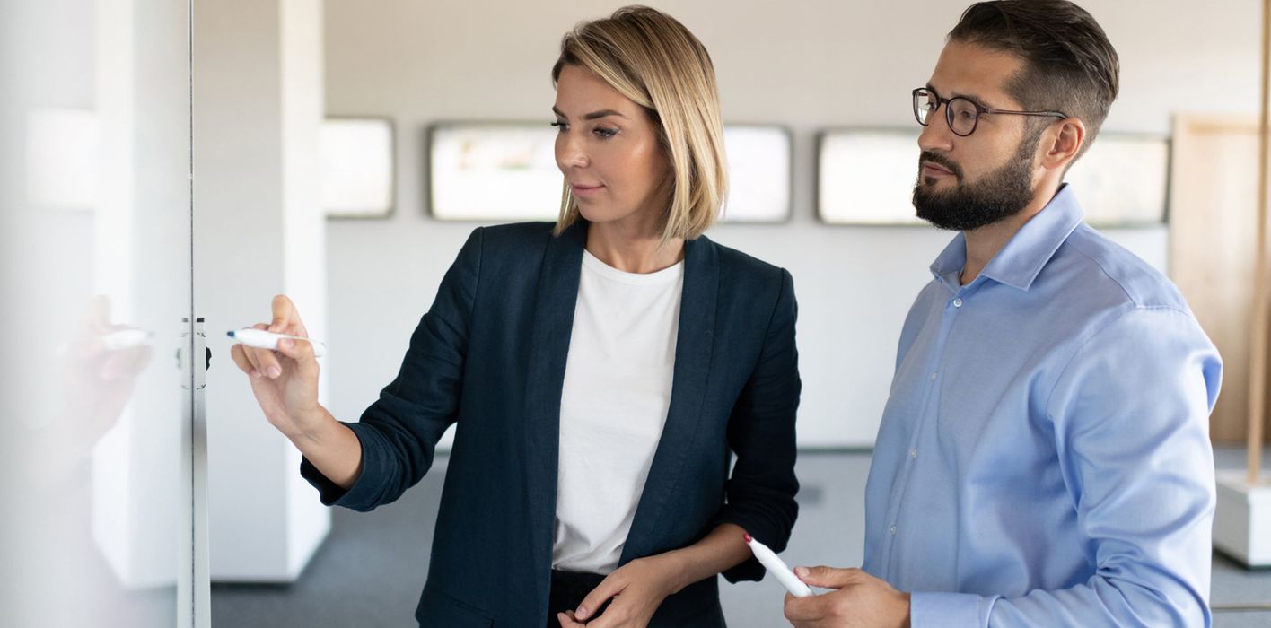 Two colleagues discuss strategic business plan in modern office