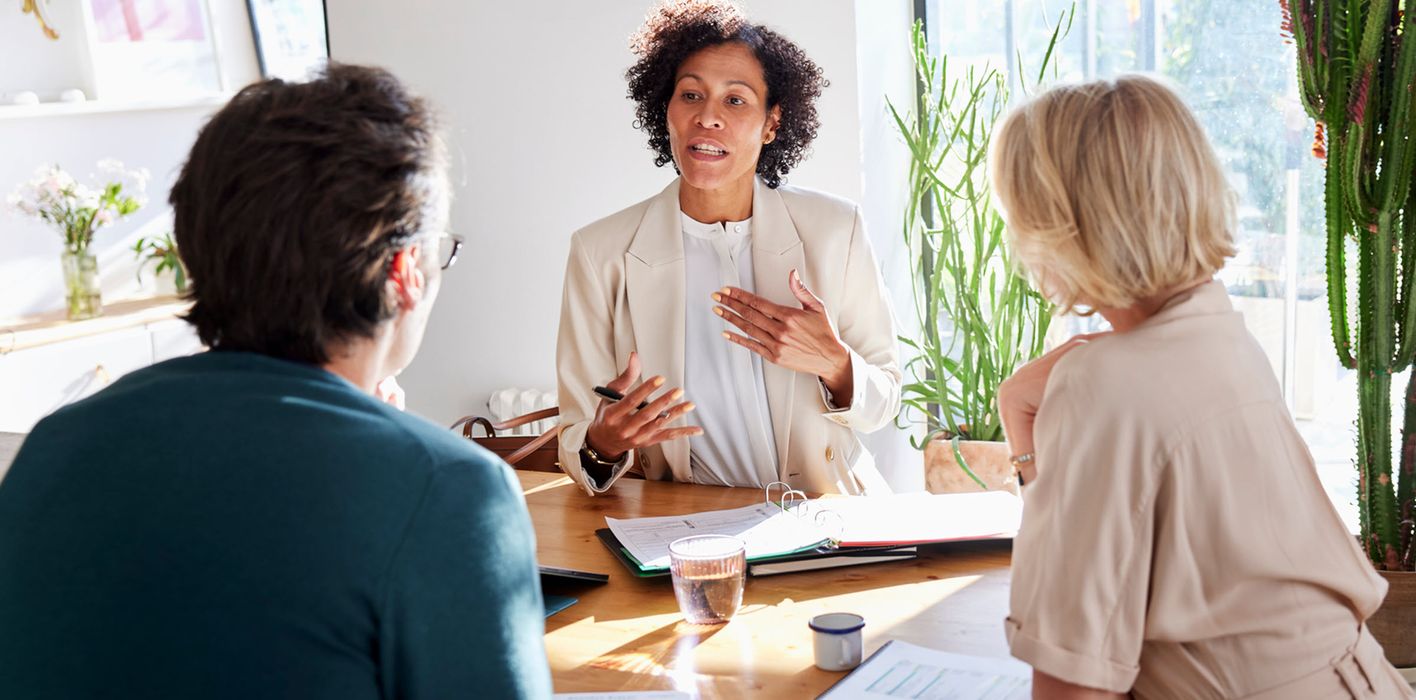 Financial advisor meeting with couple at table in modern home