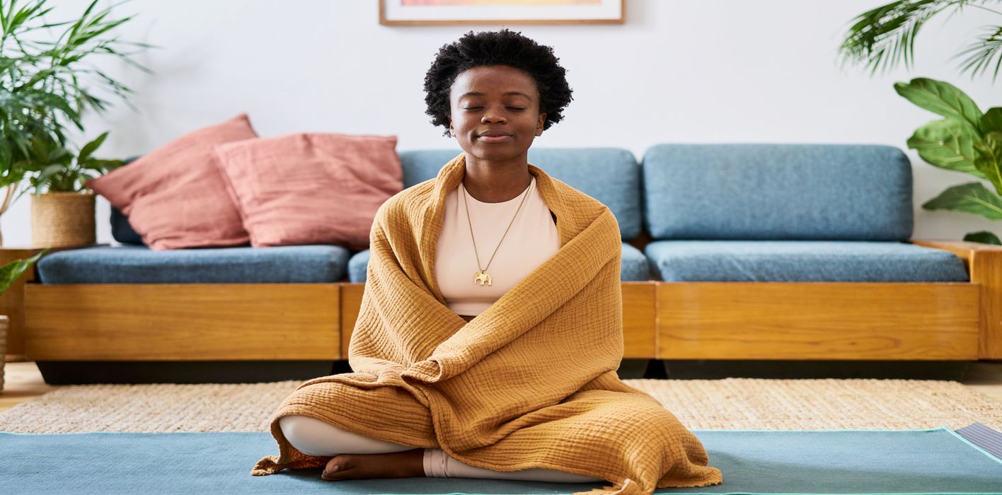 A woman meditating with a blanket