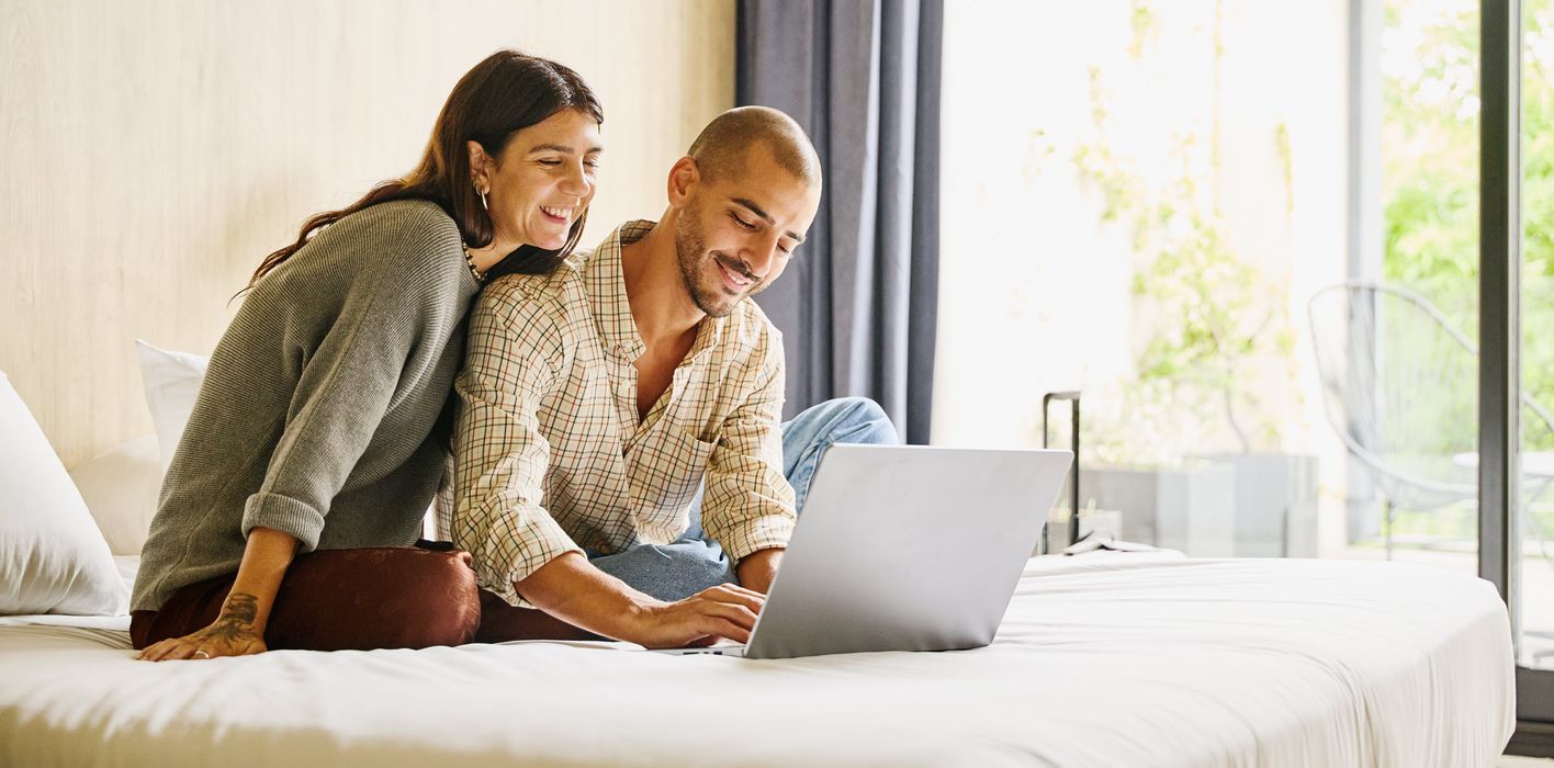 Shot of smiling couple planning finances on laptop