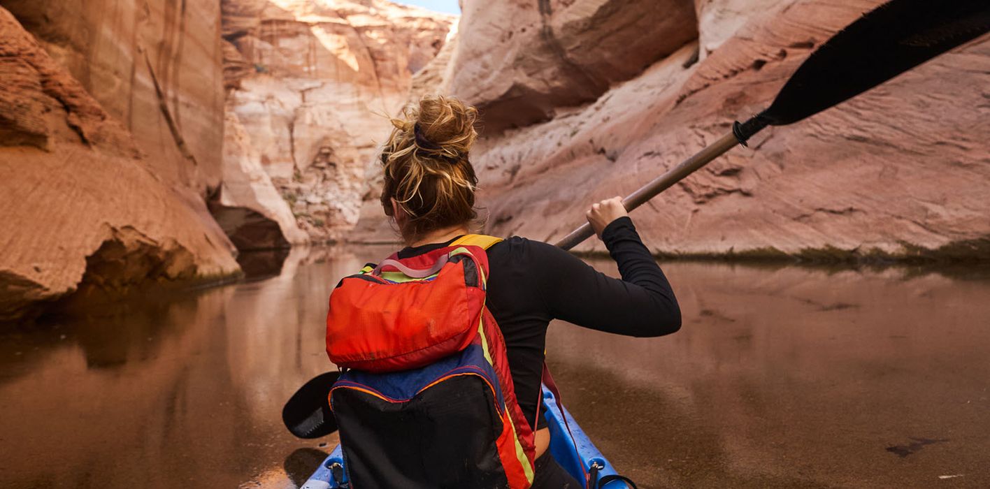 Woman kayaking and enjoying her financial freedom by maintaining a diversified portfolio with Northwestern Mutual Wealth Management Company