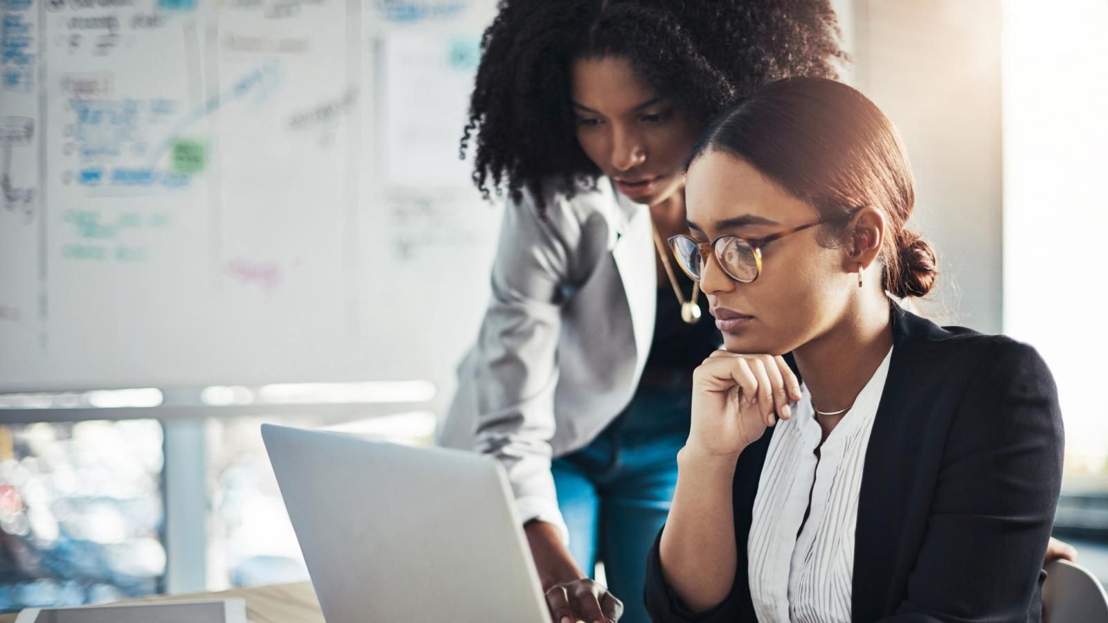 career-coach-helping-professional-woman-on-laptop