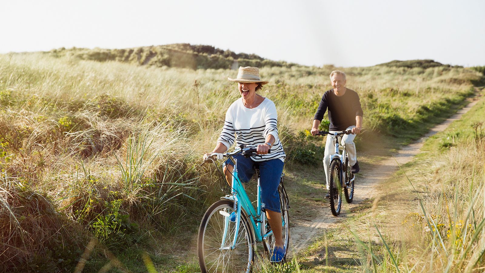 couple riding bikes in an open field