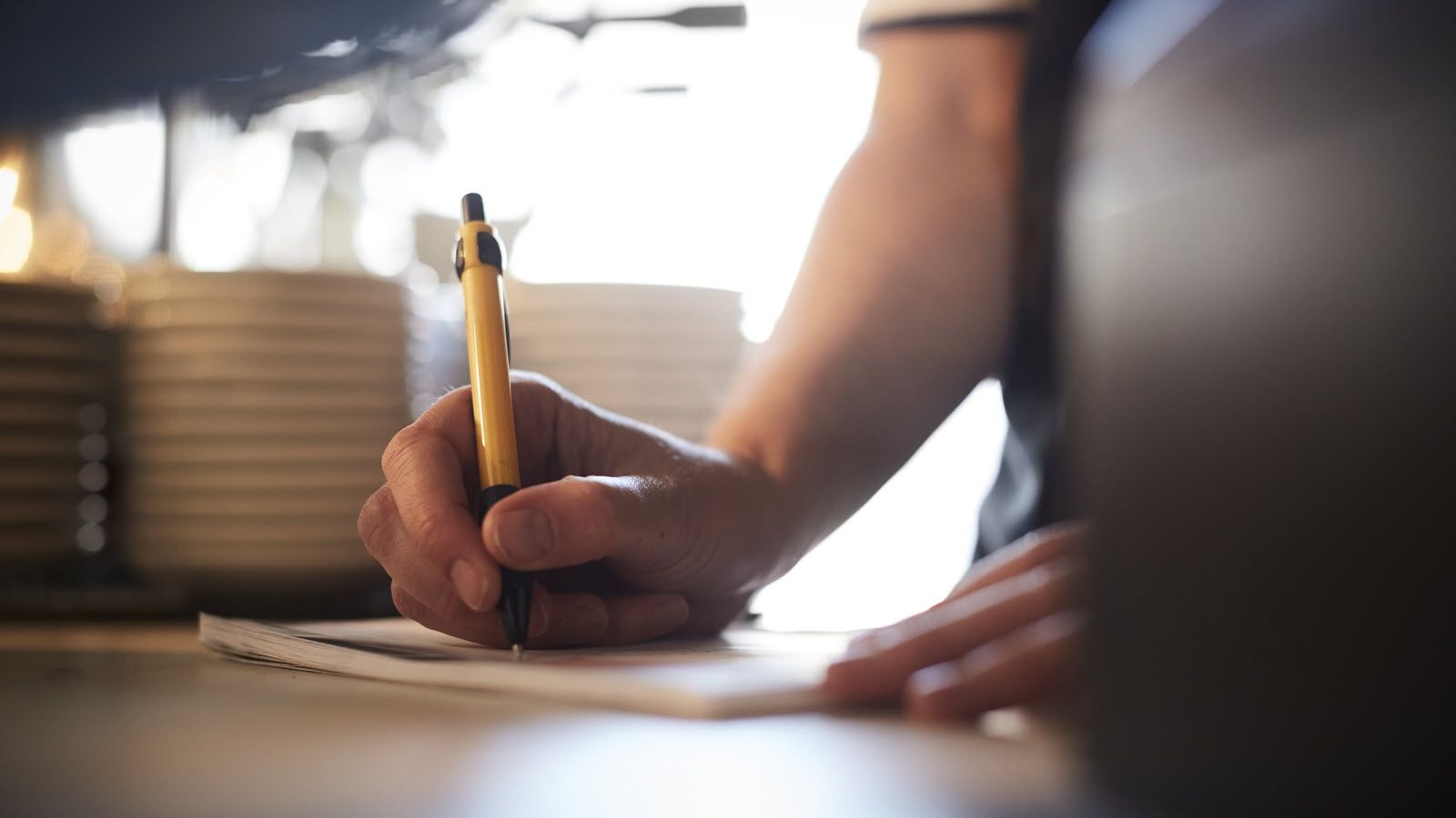 Woman writing checklist as she prepares to return to work after a disability.