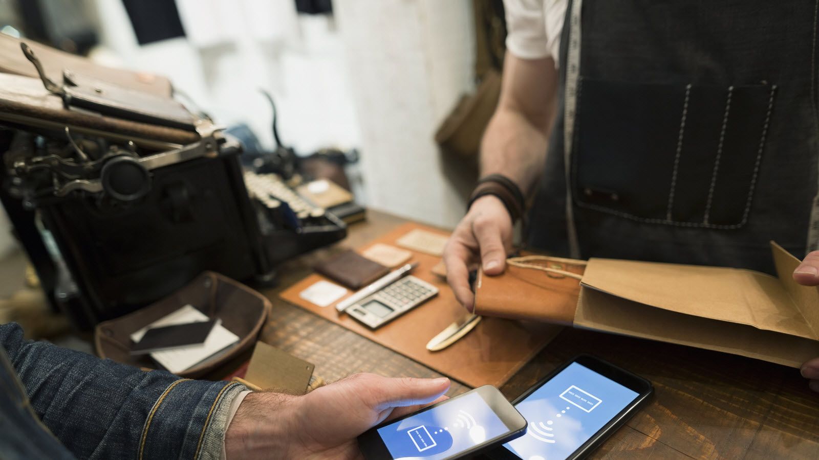 A customer uses smartphone to make a cashless purchase at small business