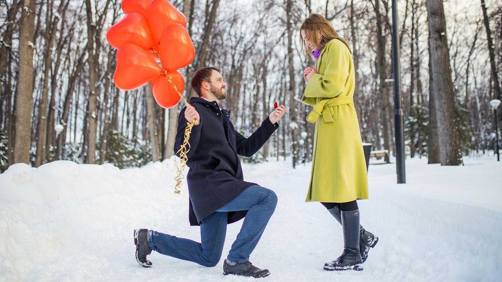 couple getting engaged on snowy outdoor path