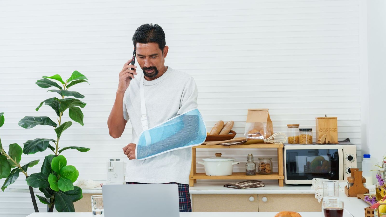 Man at home with injured arm