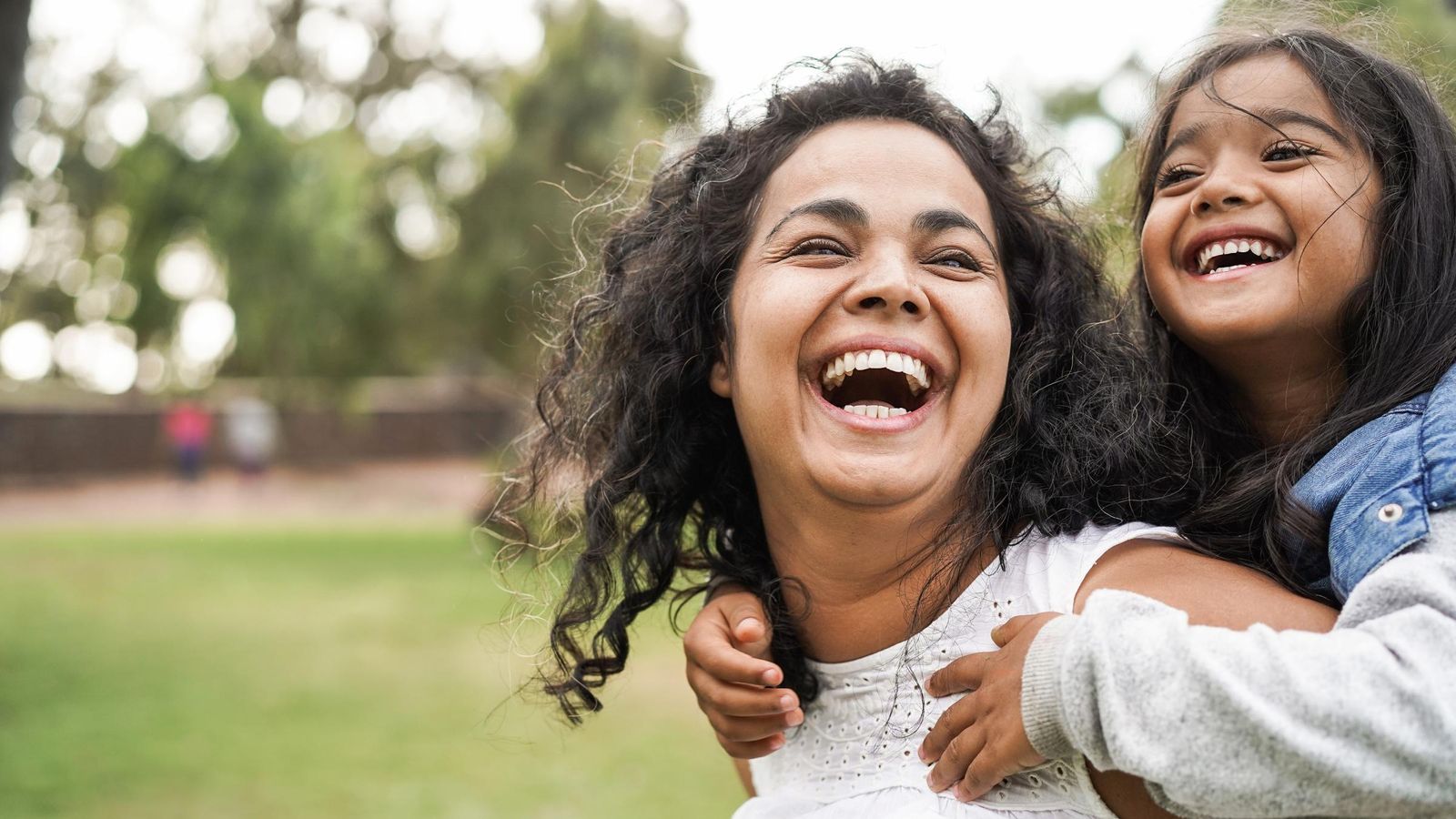 Happy mother having fun with her daughter outdoors