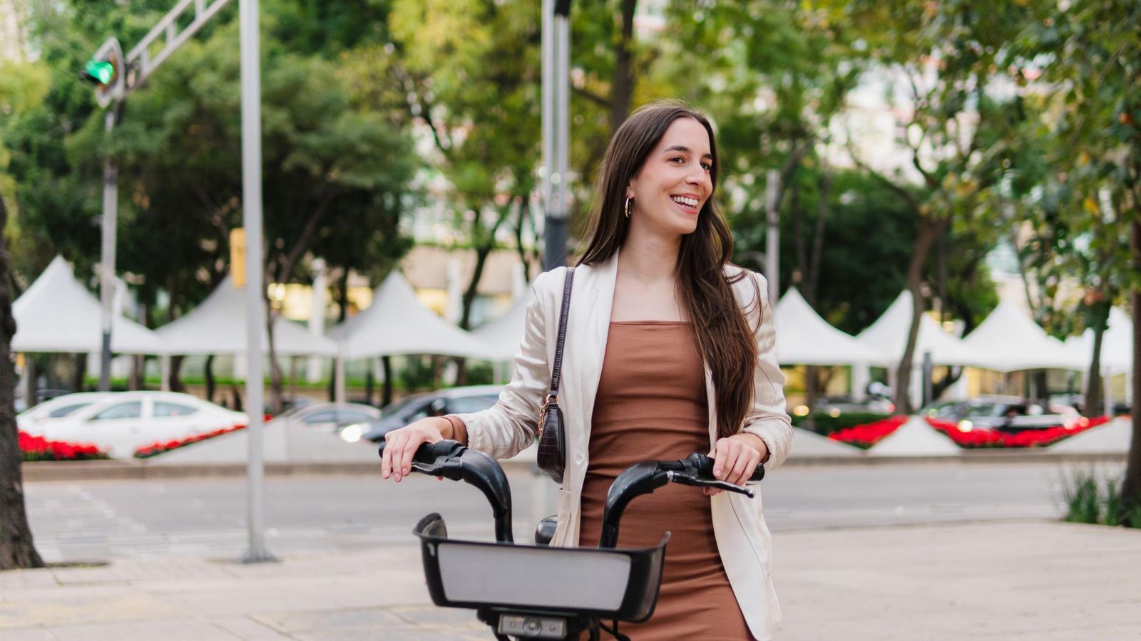 A young woman with straight hair on the street using a bicycle
