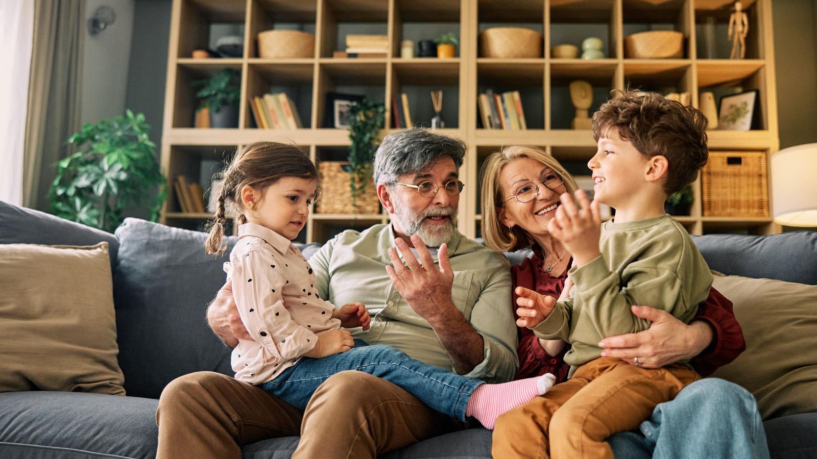Grandparents talking with grandchildren on sofa
