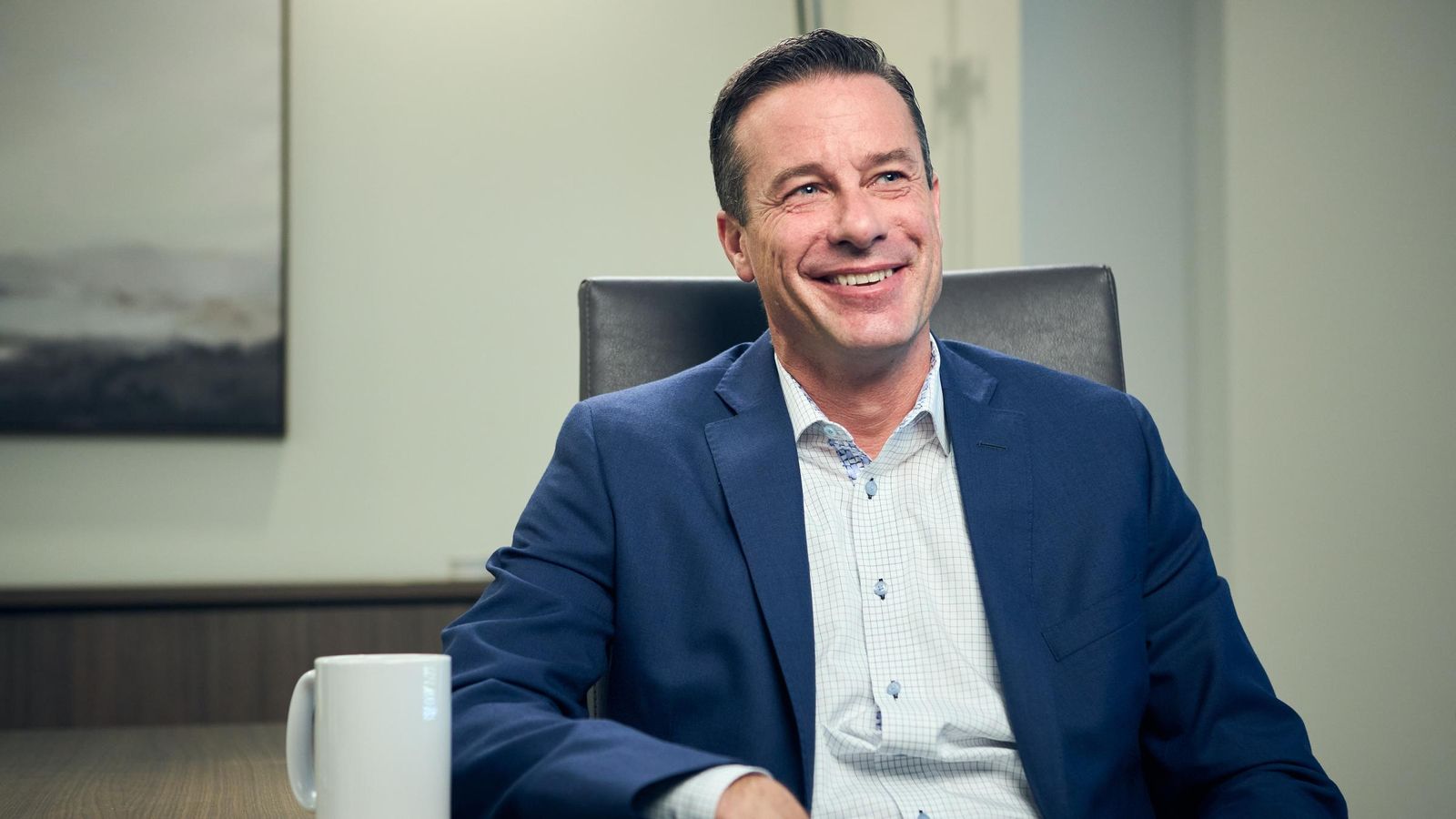 Male advisor, businessperson smiling at desk