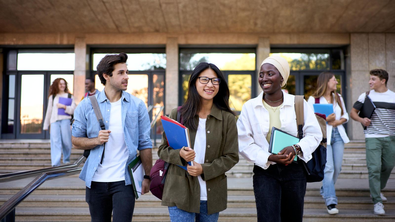 Students walking out of school, talking and laughing.