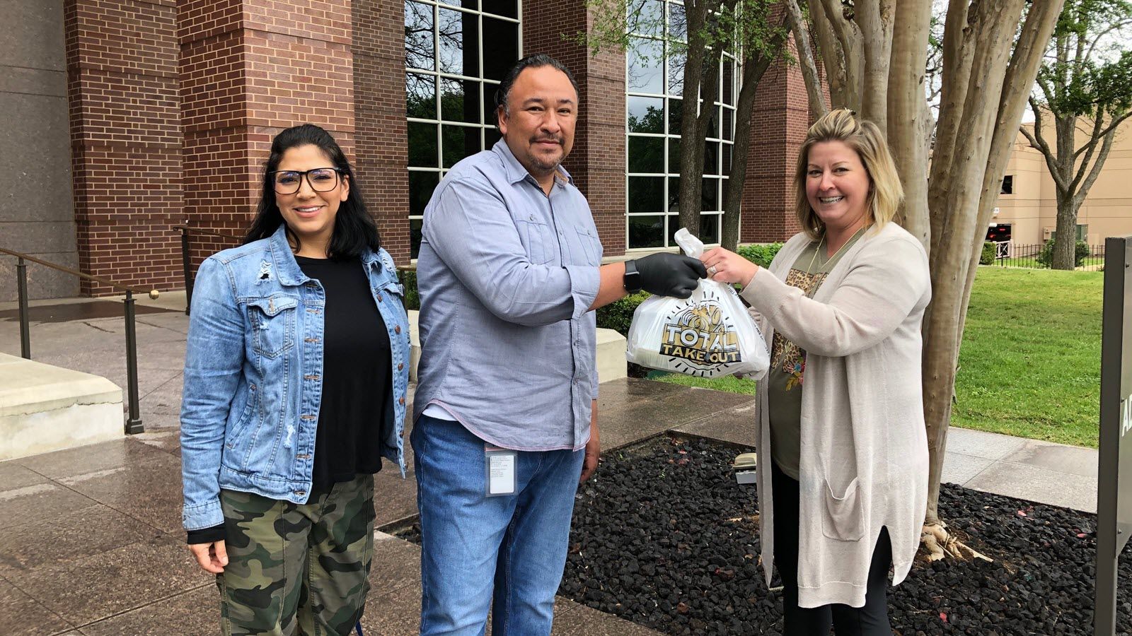 True Flavors owners Mark and Denise Hernandez delivering a meal curbside.