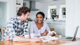 Couple at a table discussing the financial steps to take before applying for a mortgage