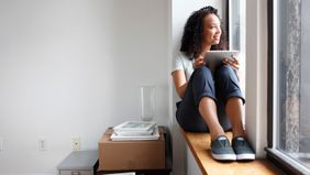 Woman in apartment wondering how much she should spend on rent