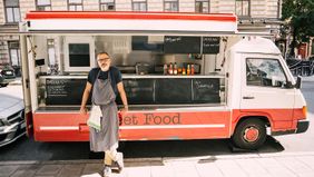 Man in front of food truck happy with his side job