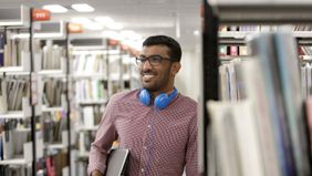 A college student thinking about their student loan debt in the library