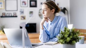 pensive woman working from home