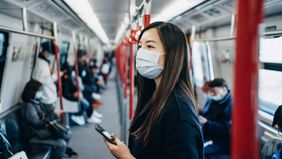 A woman checking her account on a subway