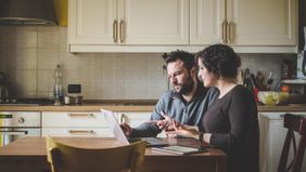 Couple trying to avoid refinancing mistakes together while looking at laptop.