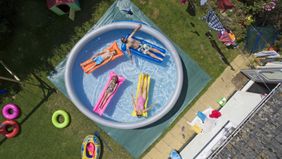 family in large padding pool in upgraded backyard