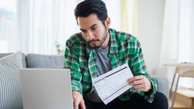 man paying bills on laptop