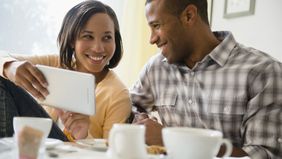 Couple looking at a tablet and discussing how variable universal life insurance works.