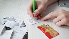 Person organizing reciepts paying down their credit card debt