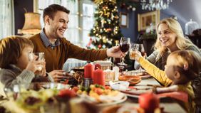Family toasting each other at a dinner table 