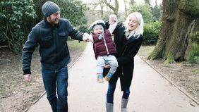 Couple playing with their child thinking about term life insurance