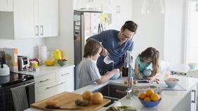 Dad cooking with his kids after learning about disability insurance