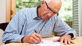 Older student loan co-signer filling out paperwork