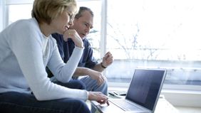 Couple looking at laptop researching can I avoid paying taxes on my 401(k) withdrawal.