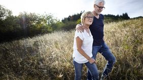 Couple walking in a field discussing when can I take money out of my 401(k)