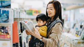 mother reading book to baby in book store