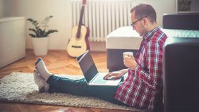 Man in his living room looking up his credit score