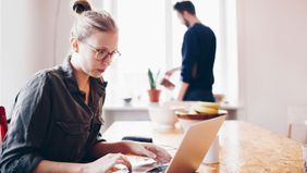 Woman in kitchen looking up what umbrella insurance is