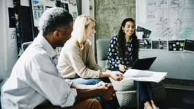 Coworkers talking about companies with the best compensation and benefits