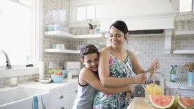 A mom and son making lemonade in the kitchen